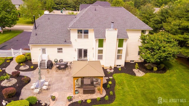 back of property with a gazebo, a patio, and outdoor dining area
