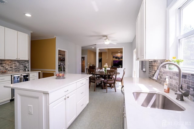 kitchen with a sink, tasteful backsplash, wine cooler, healthy amount of natural light, and recessed lighting