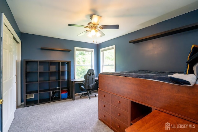 carpeted office space with ceiling fan and baseboards