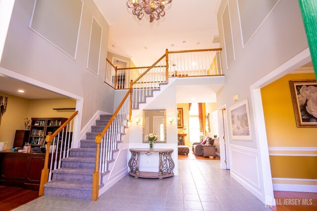 10 Magnolia Ct, Monroe, NJ 08831 - stairway with a high ceiling, a chandelier, tile patterned flooring, and baseboards