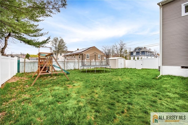 view of yard featuring a storage shed, a playground, and an outdoor structure