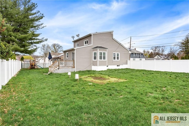 back of house featuring a playground and a deck