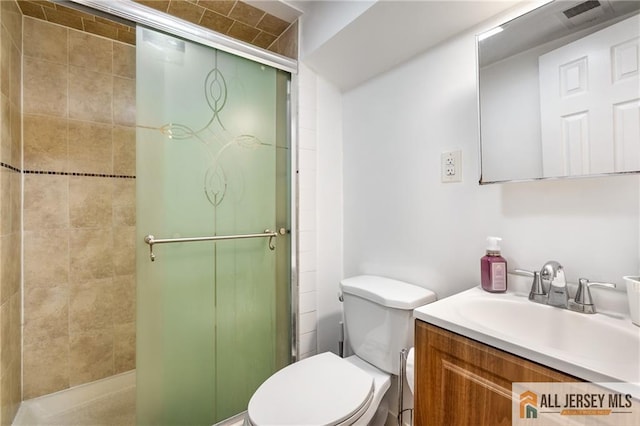 full bathroom with a shower stall, toilet, and vanity