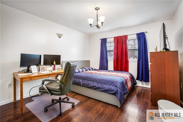 bedroom featuring a chandelier, wood finished floors, a desk, and baseboards