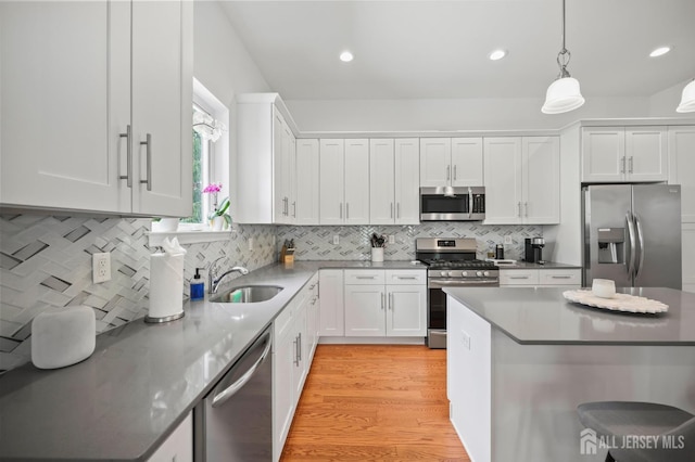 22 Sadowski Dr, Old Bridge, NJ 08857 - kitchen featuring appliances with stainless steel finishes, white cabinets, light wood-style floors, pendant lighting, and tasteful backsplash