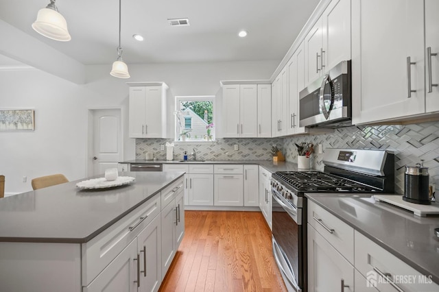 22 Sadowski Dr, Old Bridge, NJ 08857 - kitchen with stainless steel appliances, white cabinetry, decorative backsplash, pendant lighting, and light wood-style floors