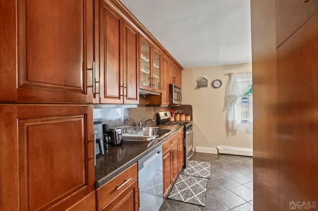 kitchen with backsplash, stainless steel appliances, sink, a baseboard radiator, and dark tile patterned flooring