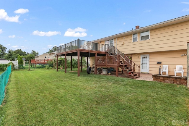 rear view of house with a lawn and a wooden deck