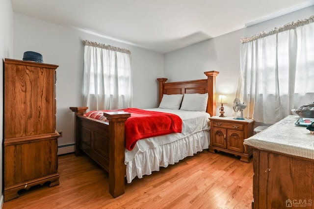 bedroom featuring light wood-type flooring and a baseboard radiator