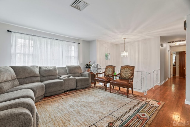 living room with plenty of natural light, an inviting chandelier, and hardwood / wood-style flooring