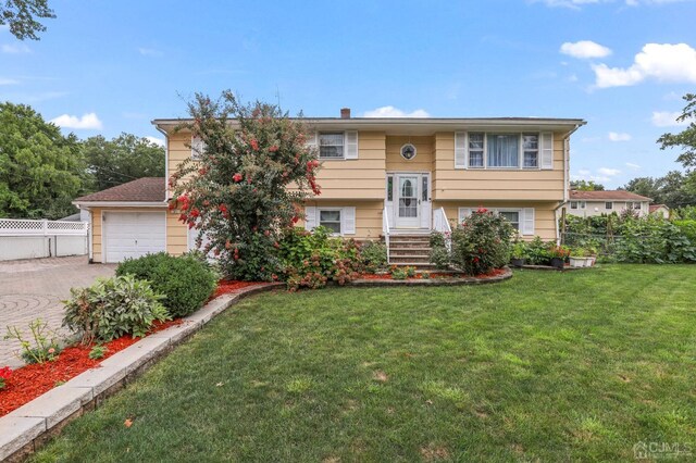 bi-level home with a garage and a front lawn