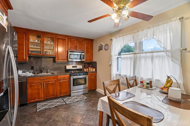 kitchen with decorative backsplash, ceiling fan, sink, and appliances with stainless steel finishes