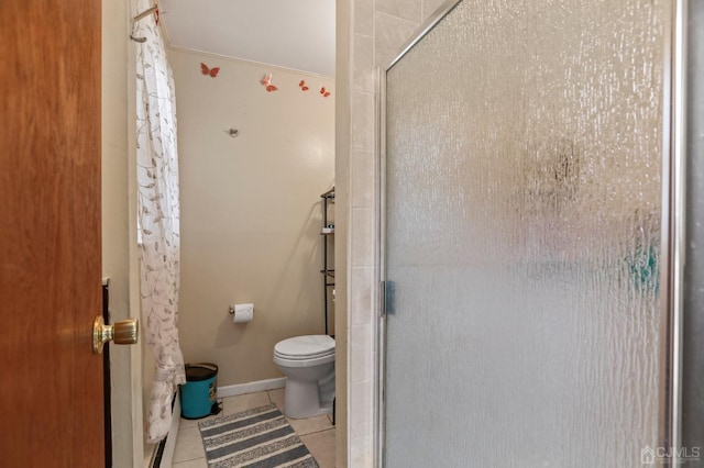 bathroom featuring tile patterned flooring, toilet, and an enclosed shower