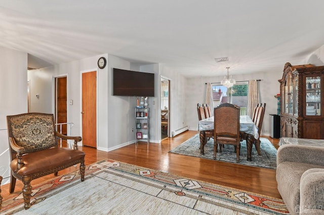 dining space with a chandelier, hardwood / wood-style floors, and a baseboard radiator