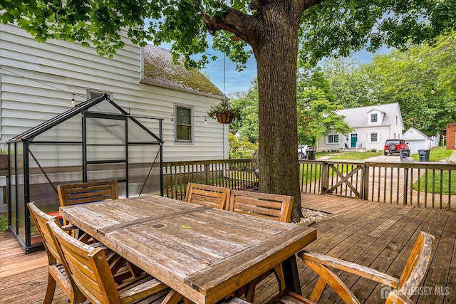 414 Graham St, Highland Park, NJ 08904 - wooden terrace with outdoor dining area, an outbuilding, and a greenhouse