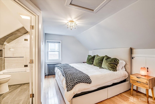 414 Graham St, Highland Park, NJ 08904 - bedroom with radiator heating unit, attic access, light wood finished floors, vaulted ceiling, and connected bathroom