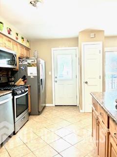 318 High St, Perth Amboy, NJ 08861 - kitchen with appliances with stainless steel finishes and light tile patterned floors