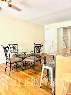 318 High St, Perth Amboy, NJ 08861 - dining room featuring light wood-type flooring, stairs, and a ceiling fan