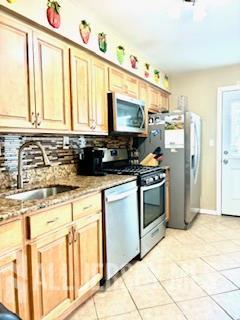 318 High St, Perth Amboy, NJ 08861 - kitchen featuring appliances with stainless steel finishes, decorative backsplash, and light tile patterned floors