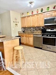 318 High St, Perth Amboy, NJ 08861 - kitchen featuring stainless steel appliances, backsplash, light brown cabinetry, and light stone countertops