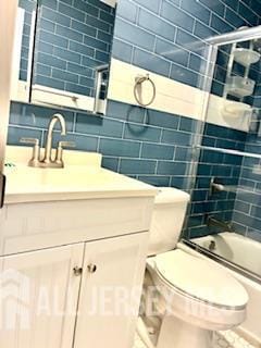 318 High St, Perth Amboy, NJ 08861 - bathroom with vanity, shower / washtub combination, tile walls, and backsplash