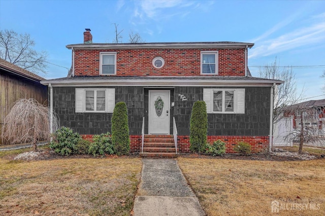 view of front of home with a chimney and a front yard