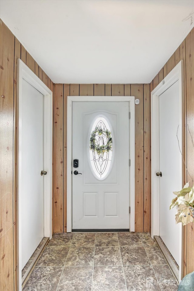 entryway with wooden walls