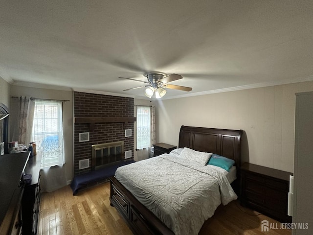 741 S Middlesex Ave S, Colonia, NJ 07067 - bedroom featuring multiple windows, ornamental molding, light wood-style floors, a fireplace, and ceiling fan
