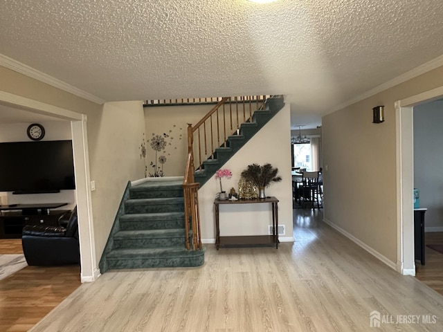741 S Middlesex Ave S, Colonia, NJ 07067 - stairs featuring wood finished floors, a textured ceiling, ornamental molding, and baseboards