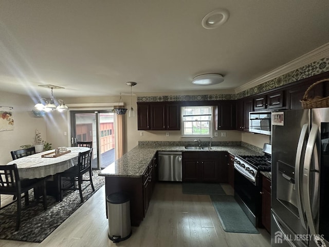 741 S Middlesex Ave S, Colonia, NJ 07067 - kitchen featuring appliances with stainless steel finishes, a peninsula, light wood-type flooring, crown molding, and decorative light fixtures