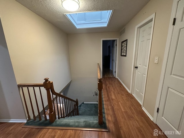 741 S Middlesex Ave S, Colonia, NJ 07067 - stairs with a skylight, wood finished floors, baseboards, and a textured ceiling