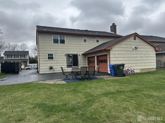 741 S Middlesex Ave S, Colonia, NJ 07067 - back of property with a chimney, a patio, a lawn, and an attached garage