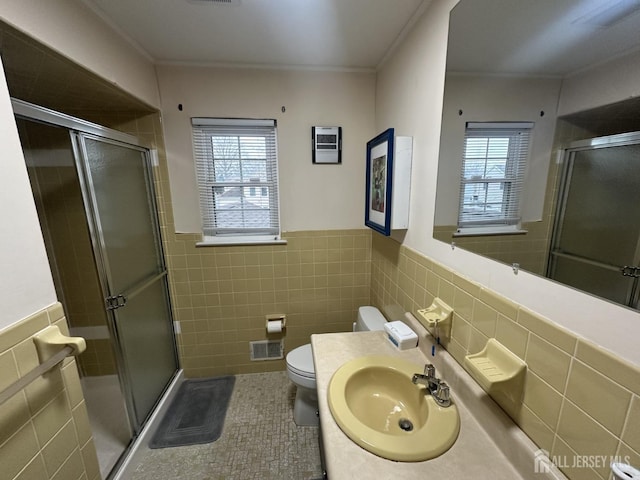 741 S Middlesex Ave S, Colonia, NJ 07067 - bathroom featuring tile walls, healthy amount of natural light, toilet, a shower stall, and a wainscoted wall