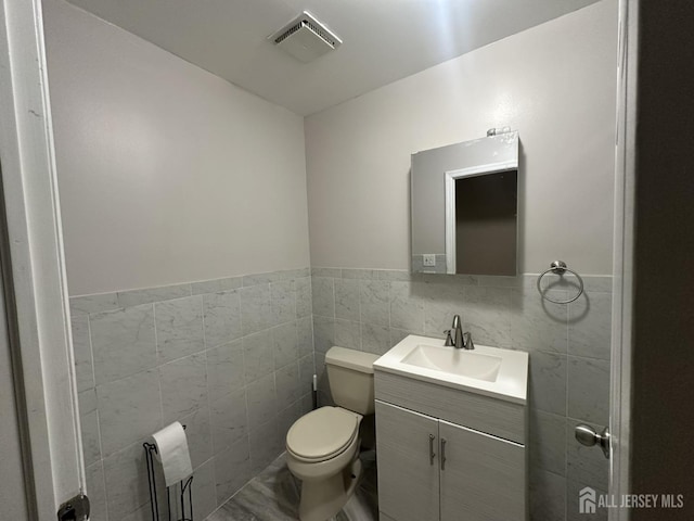741 S Middlesex Ave S, Colonia, NJ 07067 - half bath with tile walls, vanity, toilet, and a wainscoted wall