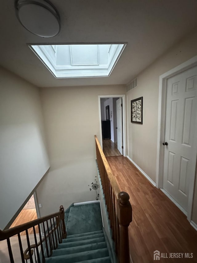 741 S Middlesex Ave S, Colonia, NJ 07067 - stairs with a skylight, wood finished floors, and baseboards