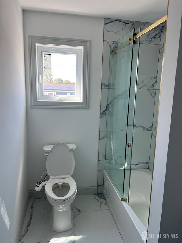 bathroom featuring combined bath / shower with glass door and toilet