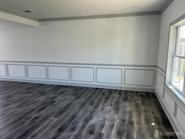 spare room with ornamental molding and dark hardwood / wood-style flooring