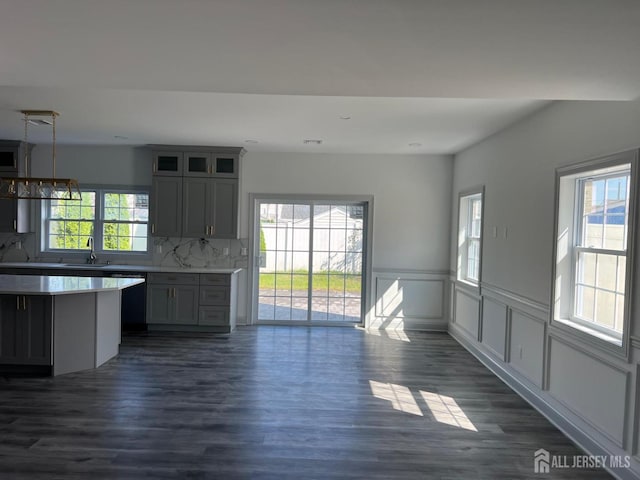 kitchen with gray cabinetry, pendant lighting, dark wood-type flooring, and a healthy amount of sunlight