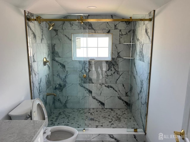 bathroom with tiled shower, vanity, toilet, and vaulted ceiling