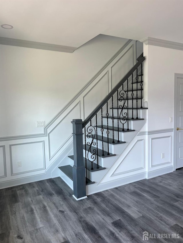 stairs with wood-type flooring and ornamental molding