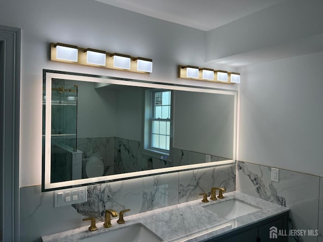 bathroom featuring decorative backsplash, a shower, and vanity