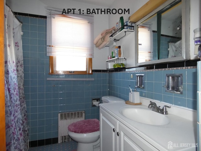 123 Heald St, Carteret, NJ 07008 - bathroom featuring radiator, vanity, plenty of natural light, tile walls, and curtained shower