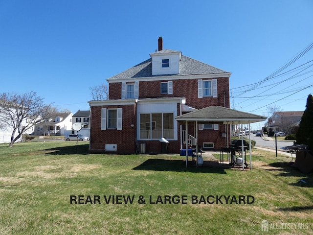 123 Heald St, Carteret, NJ 07008 - back of house with brick siding, a lawn, entry steps, and a chimney