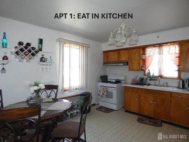 123 Heald St, Carteret, NJ 07008 - kitchen featuring white gas stove, light countertops, brown cabinets, and plenty of natural light