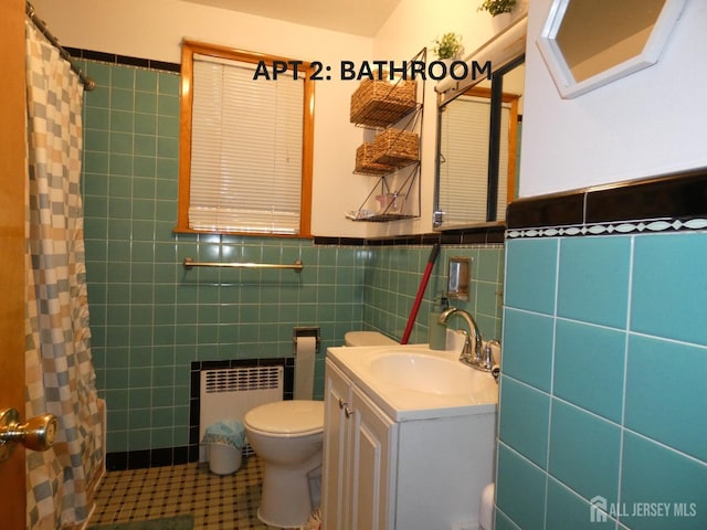 123 Heald St, Carteret, NJ 07008 - full bathroom with radiator, tile walls, vanity, tile patterned flooring, and wainscoting