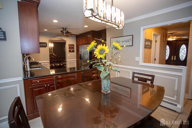 1 Stradford Rd, Sayreville, NJ 08859 - dining area with ceiling fan, a decorative wall, ornamental molding, a wainscoted wall, and arched walkways