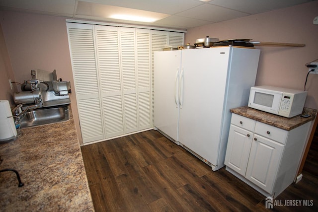 1 Stradford Rd, Sayreville, NJ 08859 - kitchen featuring white appliances, dark wood-style floors, dark countertops, white cabinets, and a drop ceiling