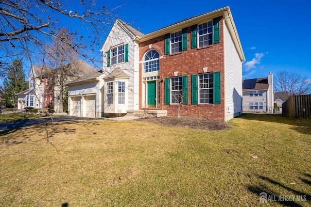 view of front facade featuring a front yard, brick siding, driveway, and fence