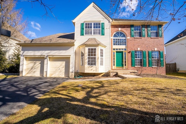 view of front of property featuring aphalt driveway, brick siding, an attached garage, and a front lawn