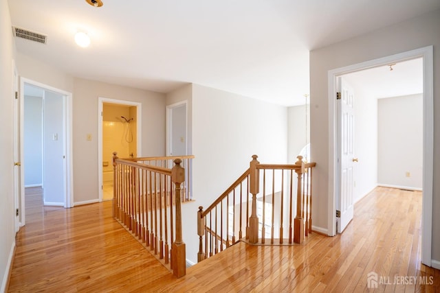 17 Larkspur Dr, South Brunswick, NJ 08810 - corridor with visible vents, baseboards, an upstairs landing, and light wood finished floors